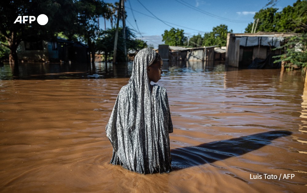 A woman wades through flood waters